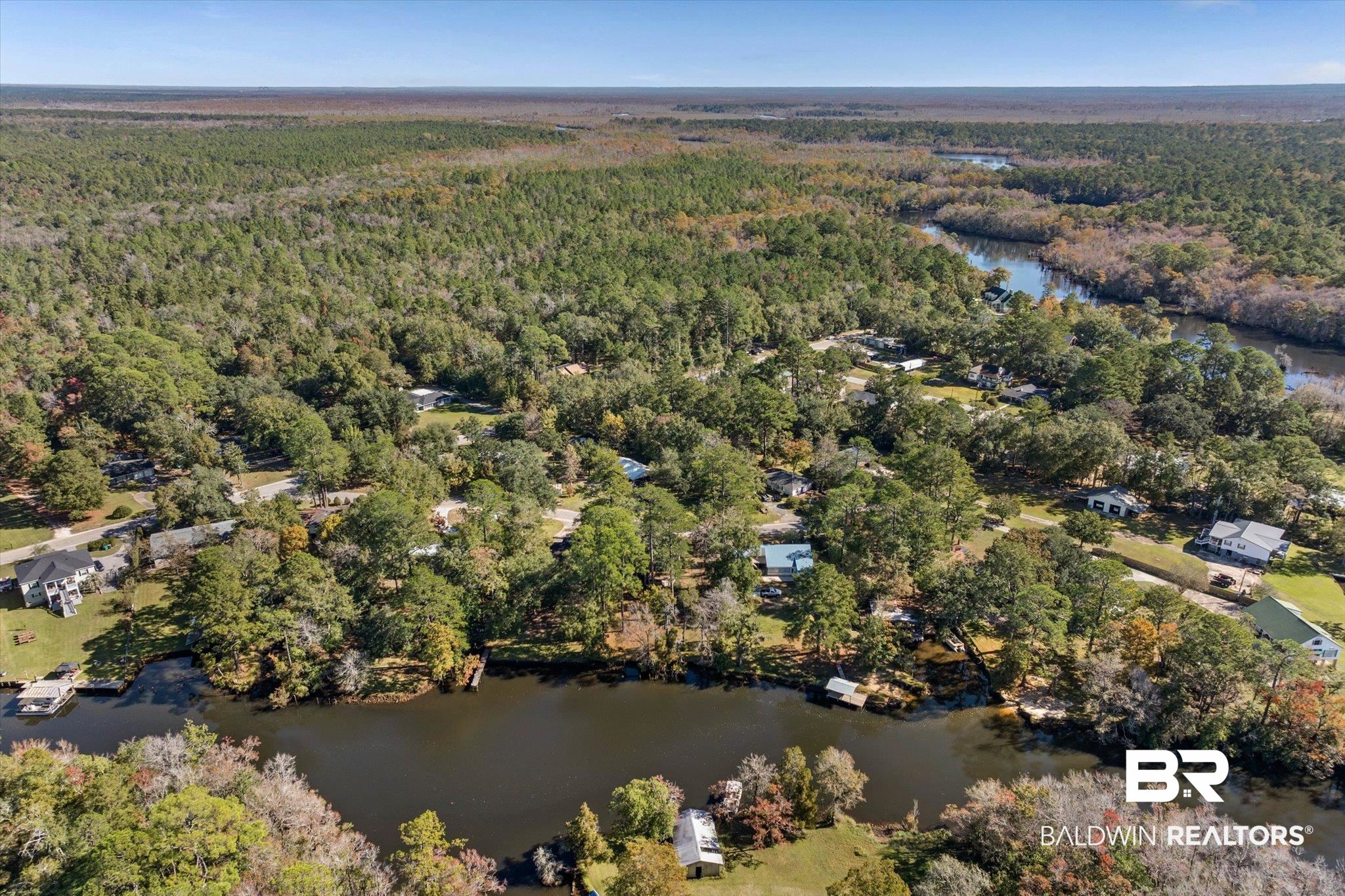 431 Simms Drive Saraland, AL 36571 - Photo 23 of 34 Aerial view of property's location with a nearby body of water and a heavily wooded area