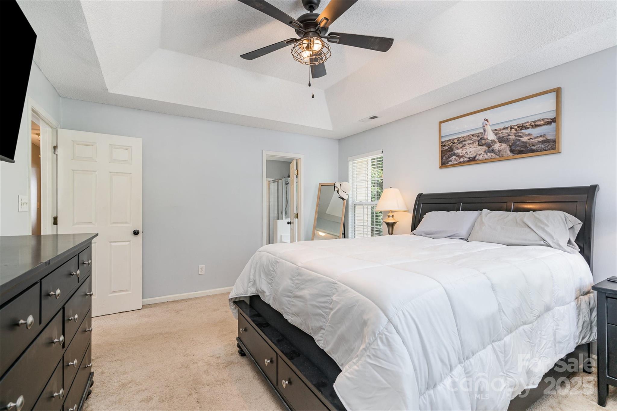 108 Shade Tree Circle Fort Mill, SC 29715 - Photo 16 of 36 a spacious bedroom with a bed and a chandelier