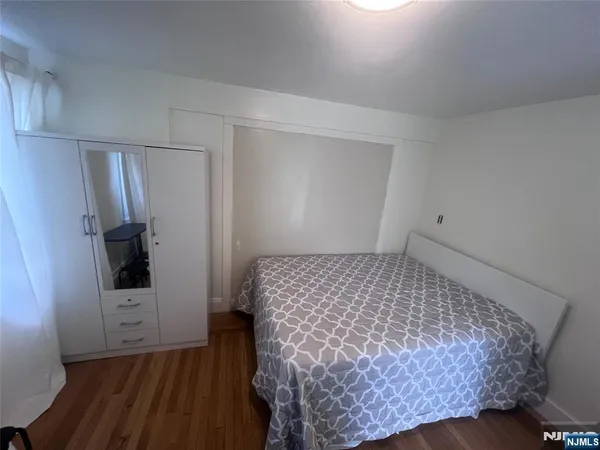 a room with a bed and wooden floor