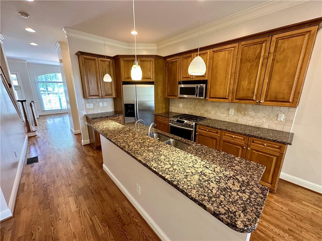 1615 Rivers Edge Trail Northeast Atlanta, GA 30324 - Photo 8 of 26 a kitchen with stainless steel appliances granite countertop a sink stove and wooden floor