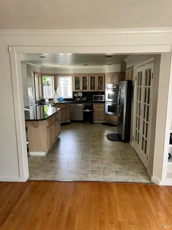 a living room with stainless steel appliances furniture and a view of kitchen