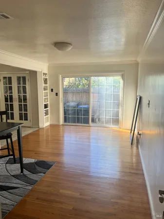 a view of empty room with wooden floor and fan