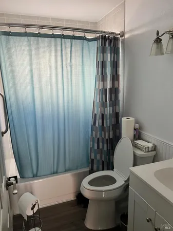 a bathroom with a toilet and a shower curtain
