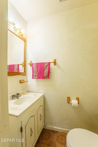 a bathroom with a sink vanity mirror and toilet