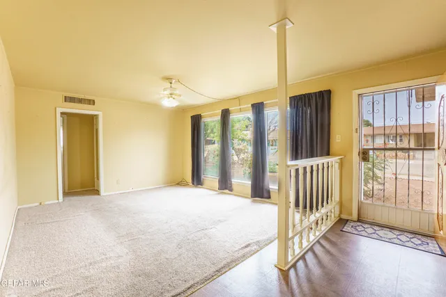 a view of a bedroom with wooden floor and windows