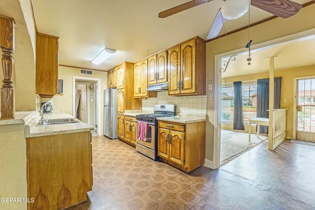 a large kitchen with stainless steel appliances granite countertop a sink and cabinets
