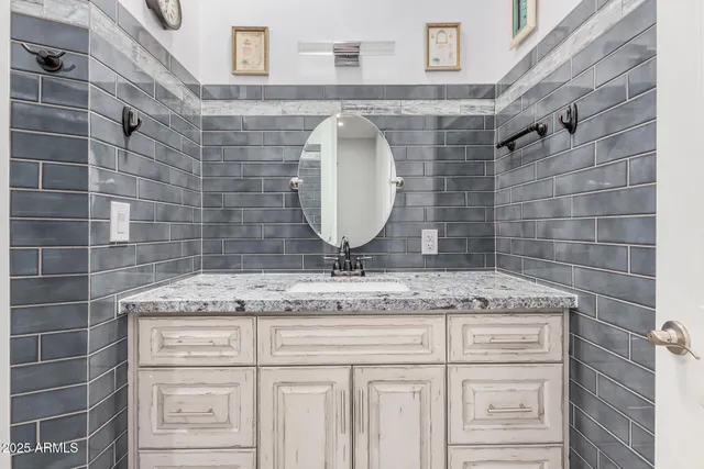 a bathroom with a granite countertop sink a mirror and shower
