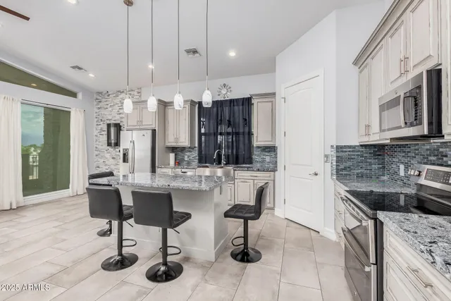 a kitchen with stainless steel appliances kitchen island granite countertop a sink and cabinets