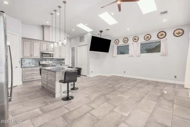 a kitchen with stainless steel appliances kitchen island granite countertop a sink and cabinets