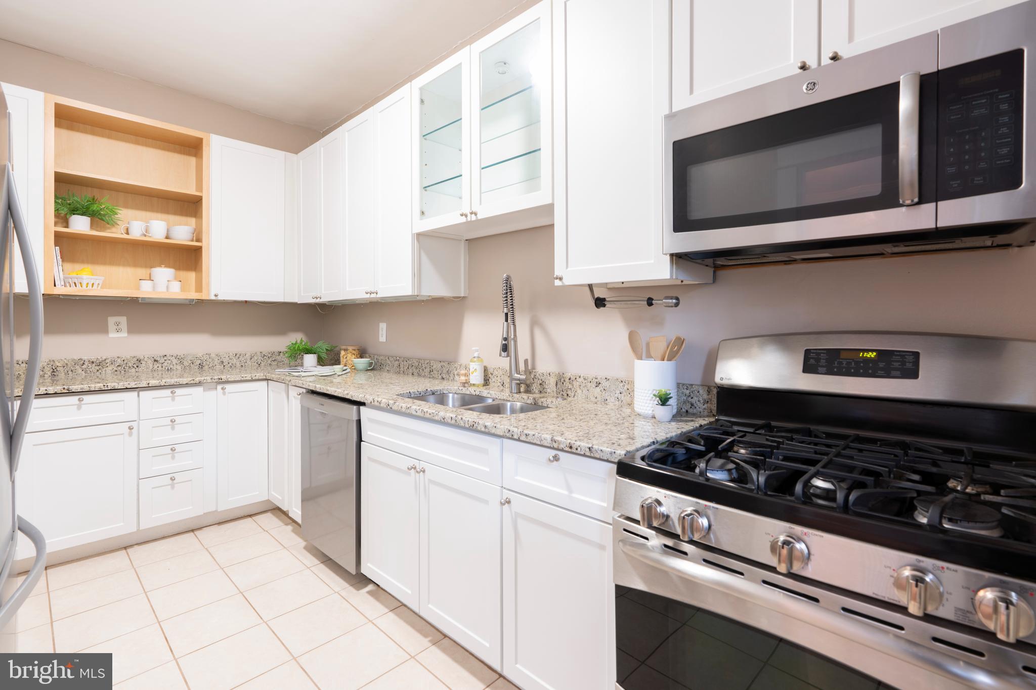3541 Newland Road Baltimore, MD 21218 - Photo 18 of 68 a kitchen with stainless steel appliances granite countertop white cabinets and window