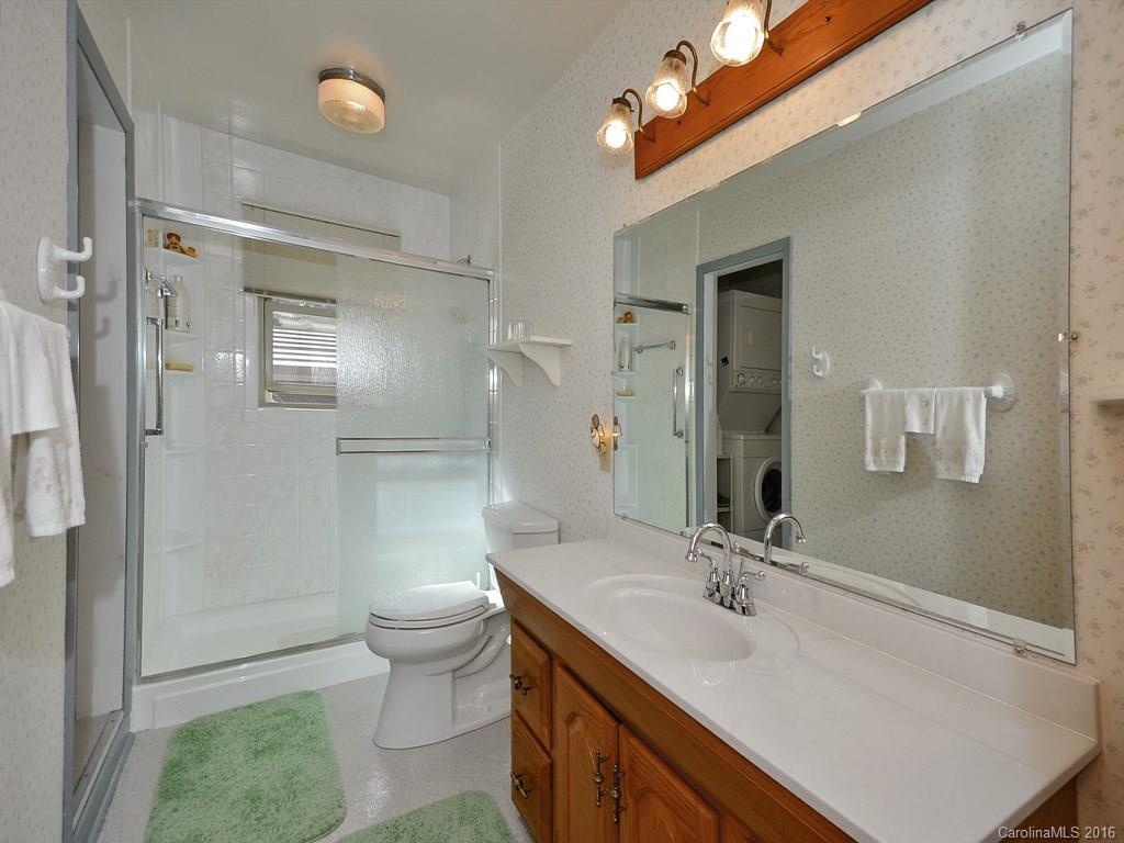 326 Robinson Road Clyde, NC 28721 - Photo 11 of 20 a bathroom with a sink a toilet a mirror and shower