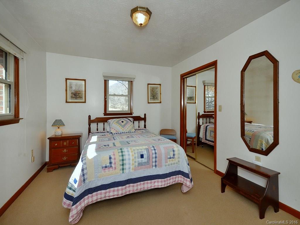 326 Robinson Road Clyde, NC 28721 - Photo 12 of 20 a bedroom with a bed a mirror and paintings on the wall