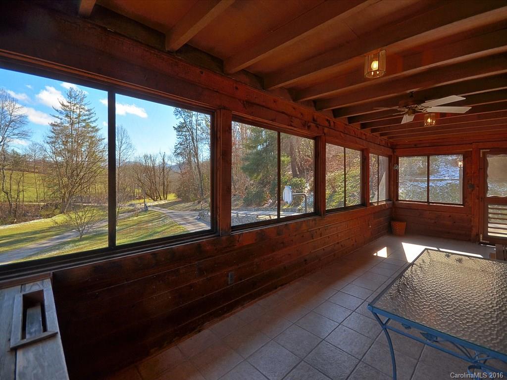 326 Robinson Road Clyde, NC 28721 - Photo 16 of 20 a view of an empty room with wooden floor and a floor to ceiling window