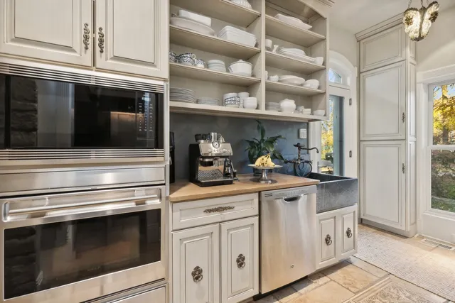 a kitchen with white cabinets and appliances