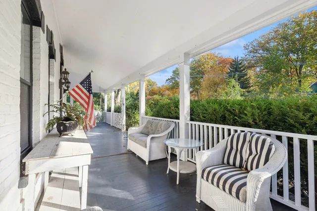 a balcony with chairs and wooden floor