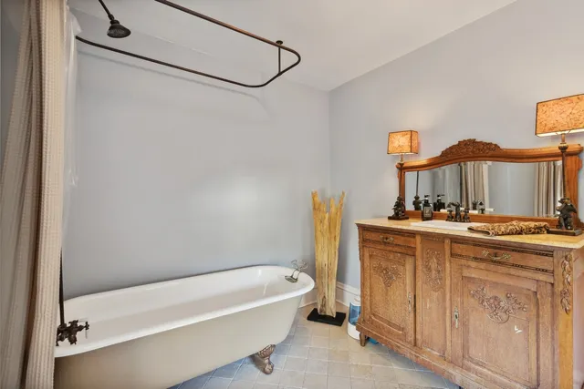 a bathroom with a tub sink and mirror
