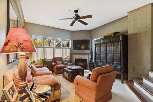 a living room with furniture fireplace and a large window