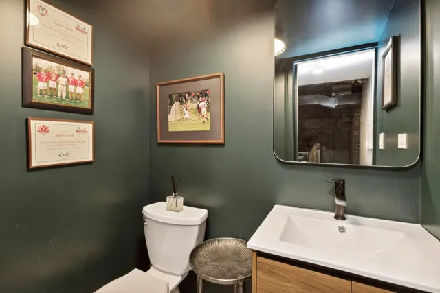 a bathroom with a toilet a sink and mirror