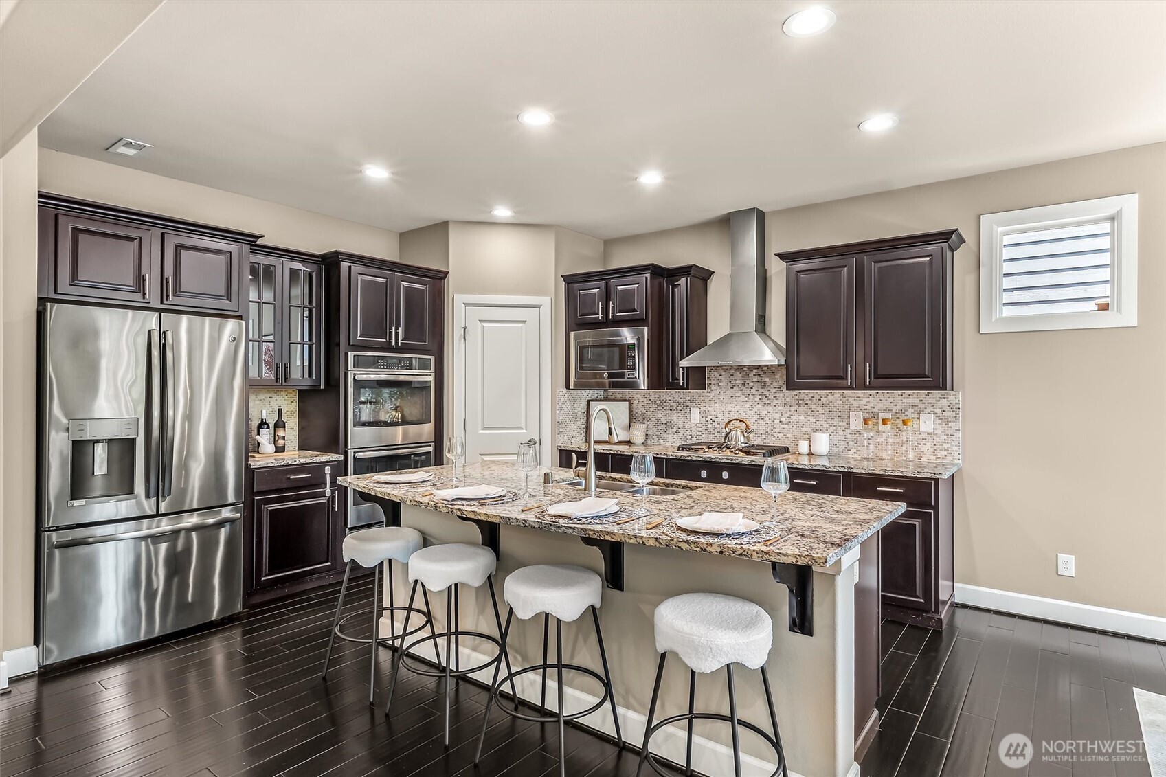 4114 174th Street Southeast Bothell, WA 98012 - Photo 11 of 40 a kitchen with stainless steel appliances granite countertop a stove a sink a refrigerator white cabinets and wooden floor