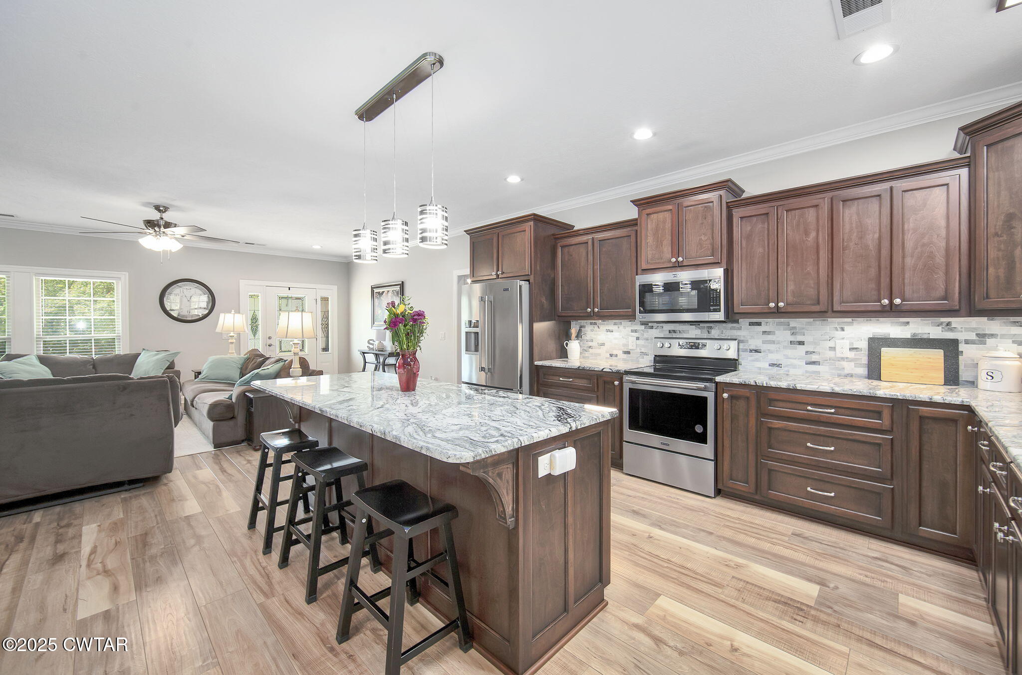 240 Greystone Cv Street Henderson, TN 38340 - Photo 18 of 64 a kitchen with stainless steel appliances granite countertop wooden cabinets a stove a sink a dining table and chairs