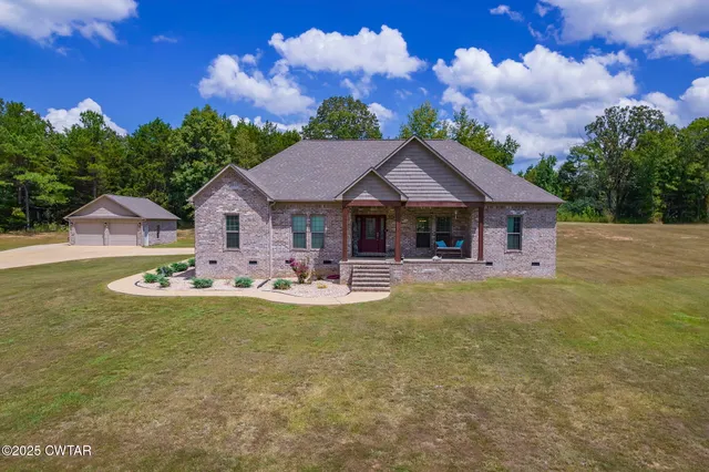 a view of a house with a big yard and large trees