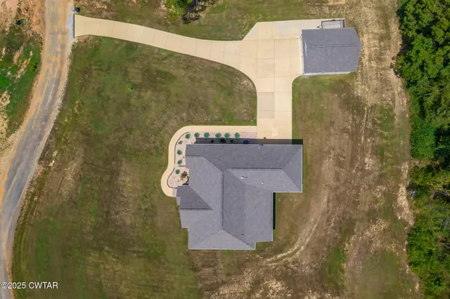 an aerial view of residential houses with outdoor space and trees