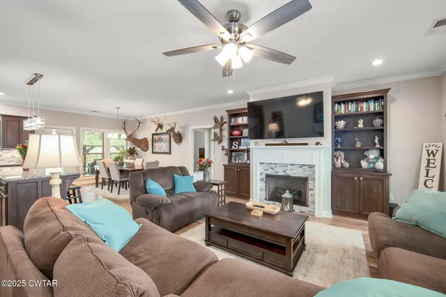 a living room with furniture kitchen view and a chandelier