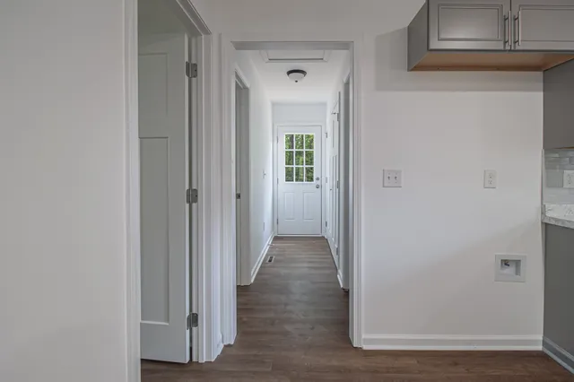 a view of a hallway with wooden floor