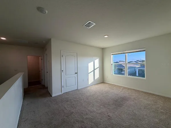 an empty room with closet and windows