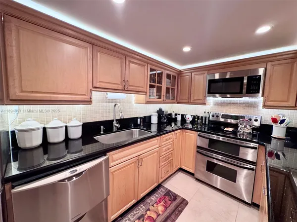 a kitchen with stainless steel appliances granite countertop a sink and a stove