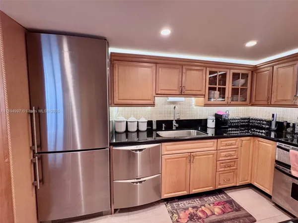 a kitchen with stainless steel appliances granite countertop a refrigerator sink and cabinets