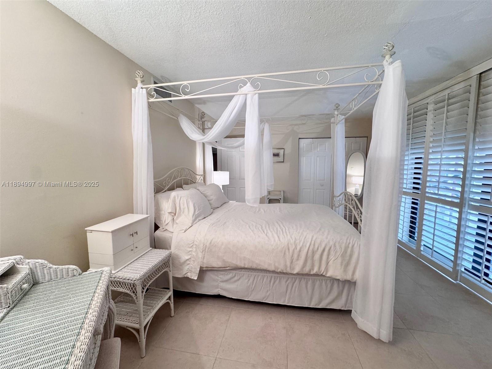 6061 Collins Avenue, Unit 10C Miami Beach, FL 33140 - Photo 33 of 45 a bedroom with a bed and a window