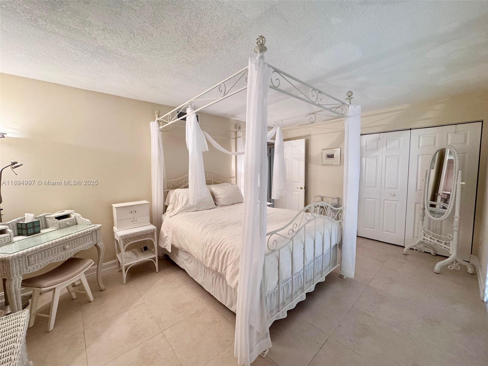 6061 Collins Avenue, Unit 10C Miami Beach, FL 33140 - Photo 34 of 45 a bedroom with a bed and a chair