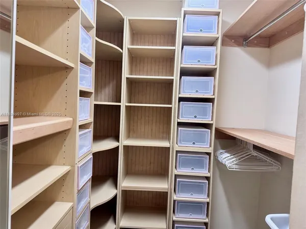 a view of walk in closet with empty racks