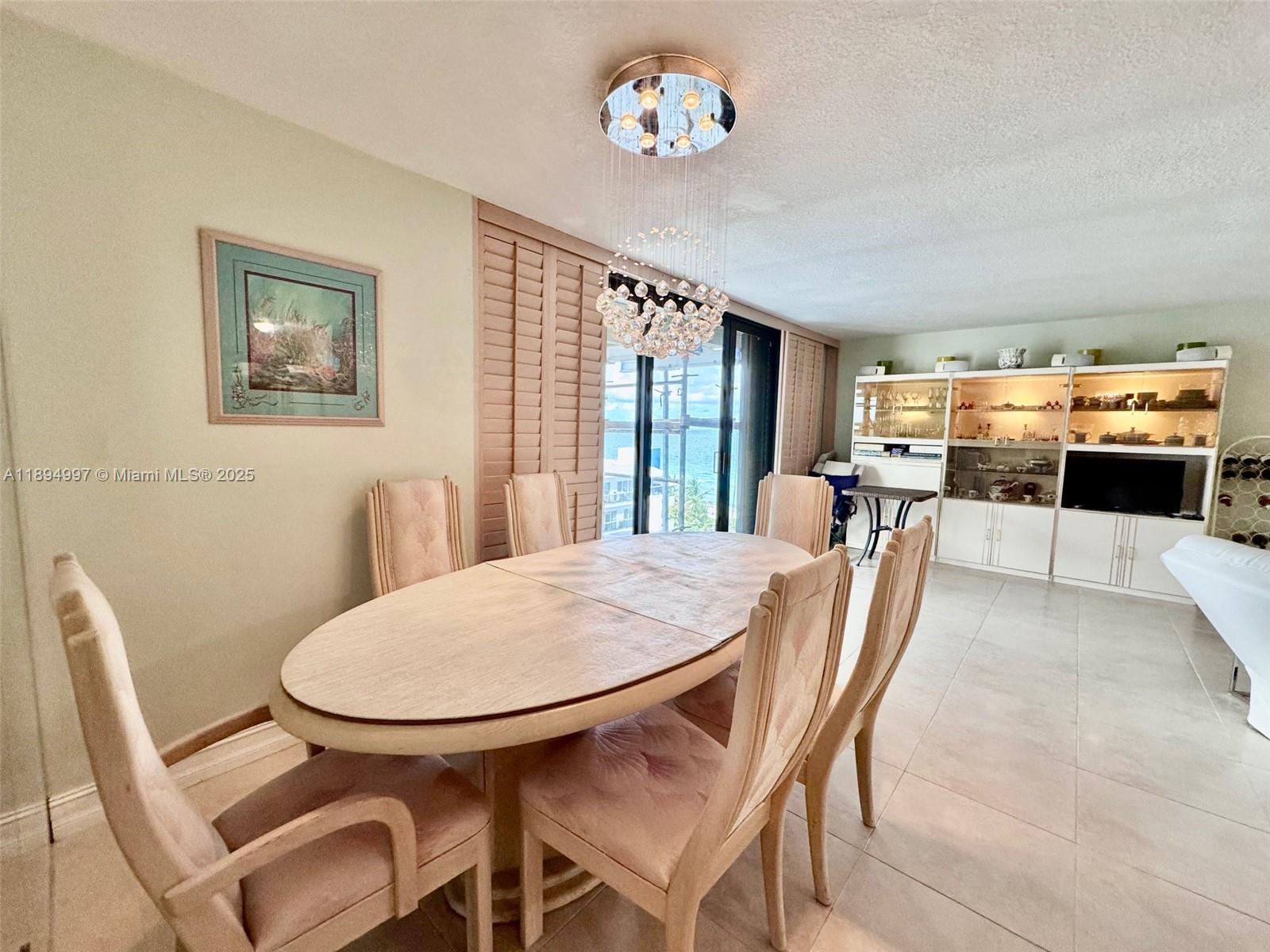 6061 Collins Avenue, Unit 10C Miami Beach, FL 33140 - Photo 10 of 45 a view of a dining room with furniture