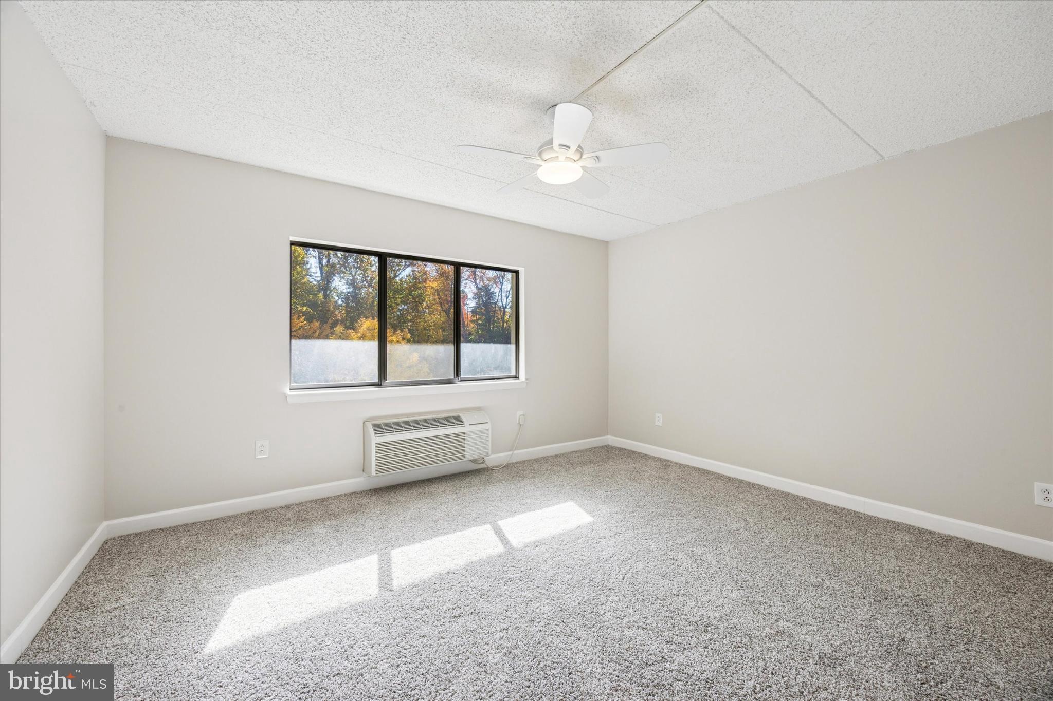 800 Avondale Road, Unit 7B Wallingford, PA 19086 - Photo 14 of 24 an empty room with windows and chandelier fan