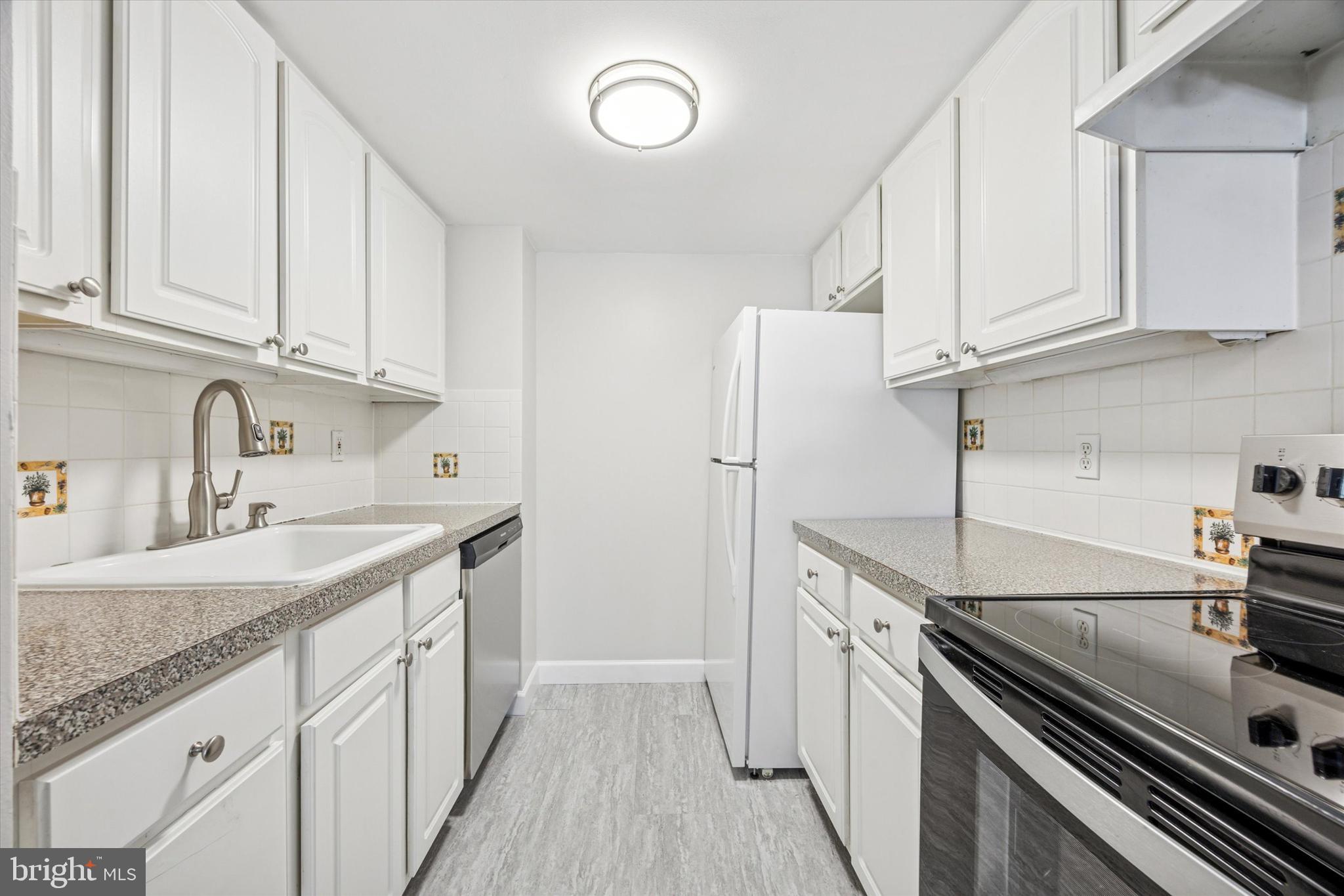 800 Avondale Road, Unit 7B Wallingford, PA 19086 - Photo 7 of 24 a kitchen with stainless steel appliances granite countertop a sink stove and refrigerator