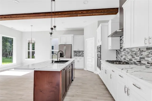 a kitchen with stainless steel appliances kitchen island granite countertop a sink and a stove