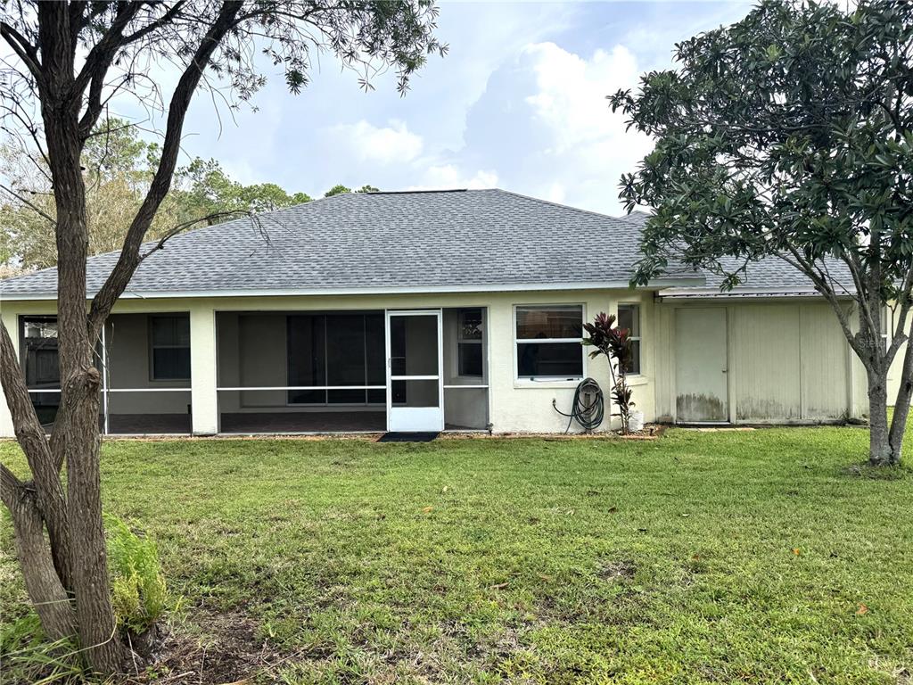 54 Westmount Lane Palm Coast, FL 32164 - Photo 30 of 32 a view of a house with a yard and a large tree