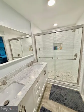 a bathroom with a granite countertop sink mirror and shower