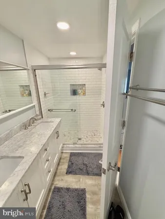 a bathroom with a granite countertop sink toilet and shower