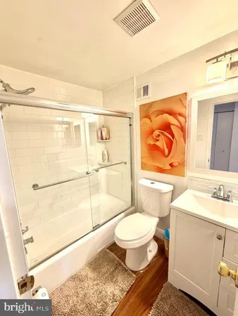 a bathroom with a granite countertop sink toilet a mirror and shower
