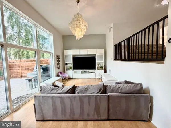 a living room with furniture a flat screen tv and a large window