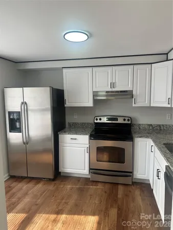 a kitchen with granite countertop a refrigerator and a stove