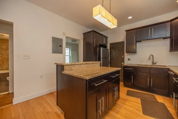 a kitchen with stainless steel appliances granite countertop a sink and a refrigerator
