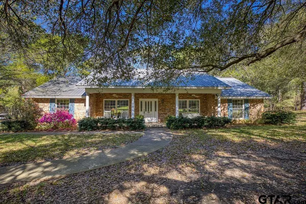 a front view of a house with a yard and trees