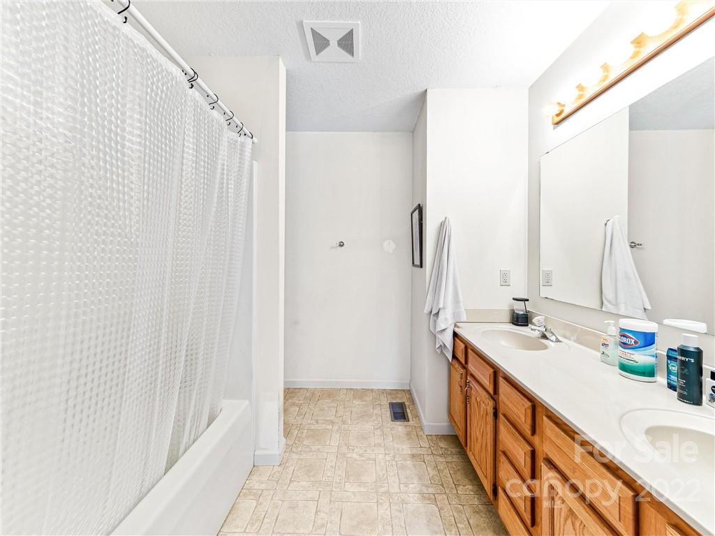 4411 Eller Ford Road Weaverville, NC 28787 - Photo 13 of 20 a bathroom with a sink a mirror and a shower curtain
