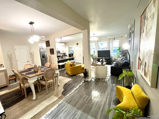 a living room with furniture a wooden floor and next to a large window