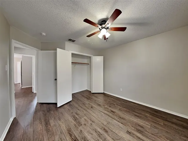 a view of a big room with wooden floor and a ceiling fan