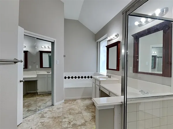 a bathroom with a tub sink and mirror